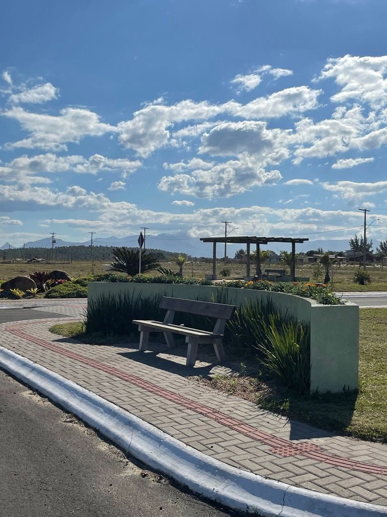 Banco e canteiro florido com vista para a serra